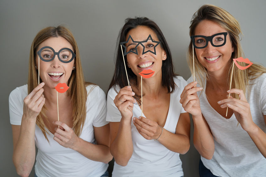 girls having fun playing with photobooth props