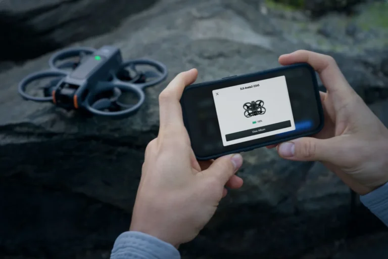 DJI Avata 2 posé au sol pendant le transfert des vidéos sur smartphone