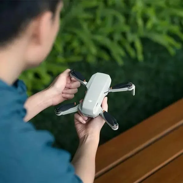 DJI Mini 4K plie tenu dans la main, format de poche