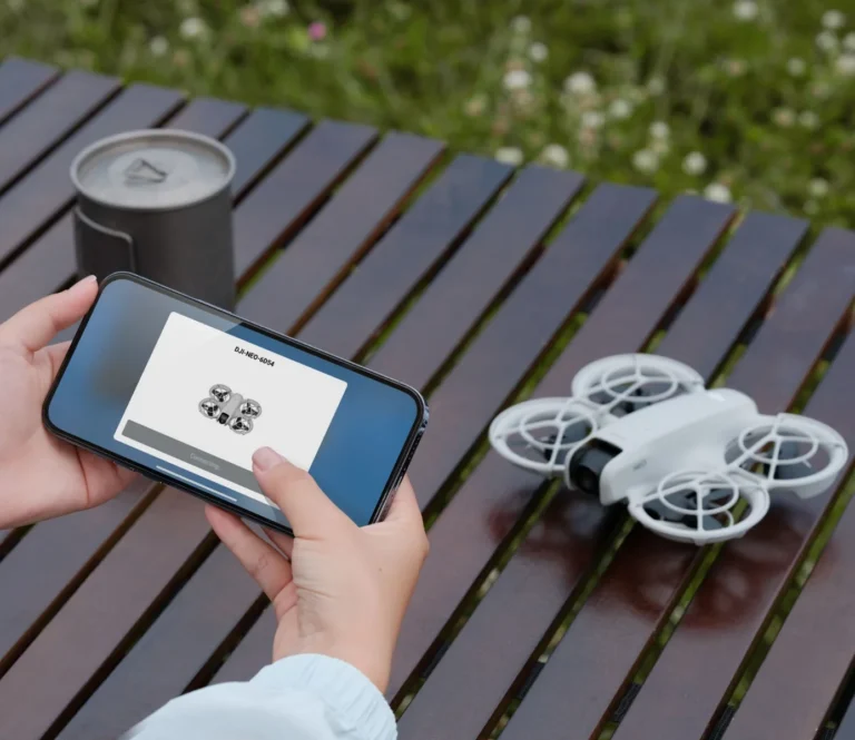 DJI Neo posé sur une table à côté d un smartphone connecté
