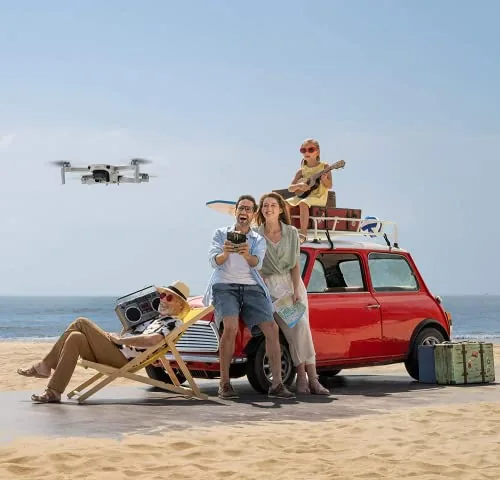 DJI Mini 2 en vol au-dessus d'une plage, piloté au smartphone