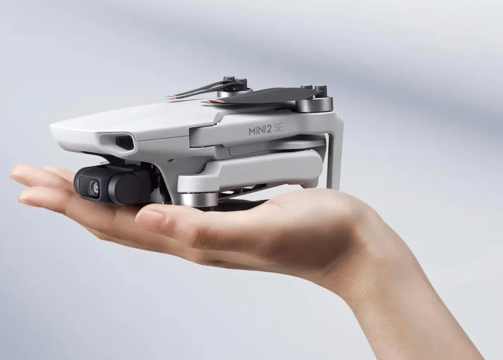 DJI Mini 2 SE plié dans la main, inscription MINI 2 SE sur le bras